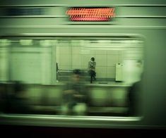 a blurry photo of a subway station with people waiting for the train to arrive