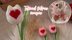 three crocheted flowers with hearts on them sitting next to each other in front of a box