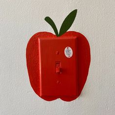 an apple shaped light switch cover on the wall