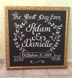 the best day ever is adam and danielle wedding chalkboard sign in gold frame on tile floor