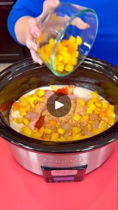 a woman pouring corn on top of a crock pot filled with rice and other ingredients