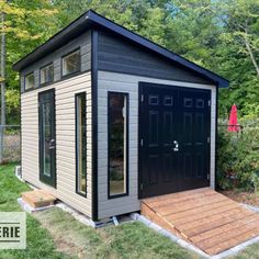 a small shed with the door open and steps up to it's front entrance