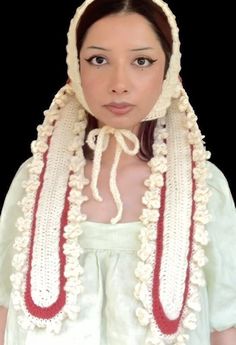 a woman wearing a white and red crochet head piece