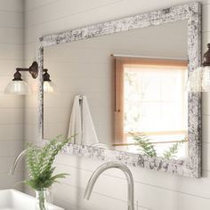 a bathroom sink sitting under a mirror next to a faucet mounted on a wall