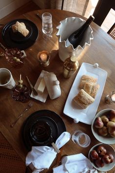 a wooden table topped with plates and bowls filled with food