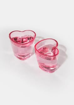 two pink heart shaped glasses sitting next to each other