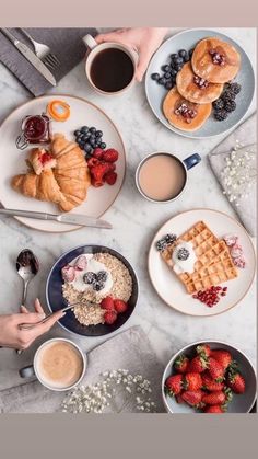 breakfast plates with croissants, strawberries, blueberries, and coffee