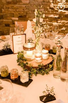 the table is set up with candles, flowers and wine glasses for guests to enjoy