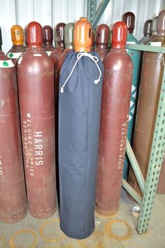 three fire extinguishers are lined up next to each other in a storage area