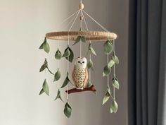 an owl mobile hanging from a tree branch