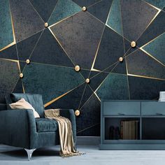 a living room with a blue couch and gold geometric wallpaper