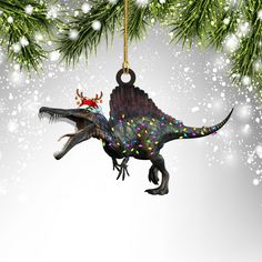 a dinosaur ornament hanging from a christmas tree with lights on it's back