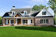 a large brick house sitting on top of a lush green field