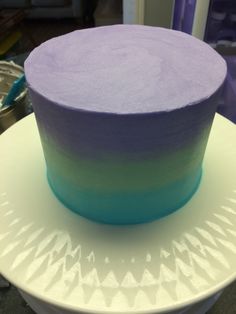 a purple and blue cake sitting on top of a white plate