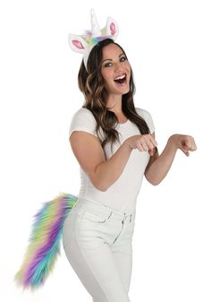 a woman in white is wearing a unicorn costume and pointing her finger at the camera