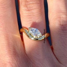 a woman's engagement ring with a pear shaped diamond set in yellow and white gold