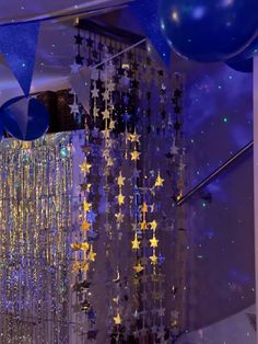 some blue and gold decorations are hanging from the ceiling with stars on them in this room