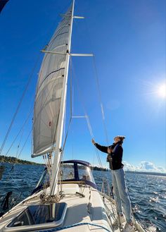 a man standing on the bow of a sailboat