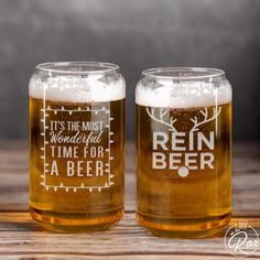 two beer mugs sitting on top of a wooden table with the words, it's the most wonderful time for a beer