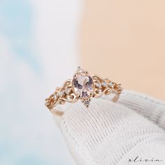 an engagement ring with a pink stone surrounded by diamonds