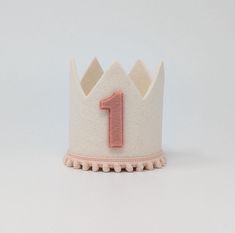 a white crown with a pink number one on it