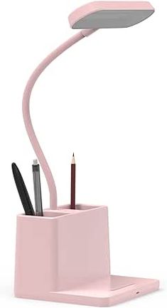 a pink desk lamp with pens and pencils in it