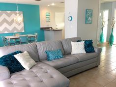 a living room filled with furniture next to a kitchen