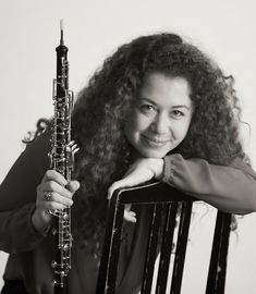 a woman sitting in a chair holding a saxophone