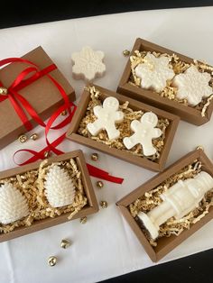 four decorated cookies in boxes on a table