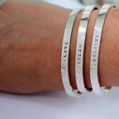 These Message Bracelets with the Word of your choice in Silver are perfect for everyday! Choose from: BREATHE LOVE DREAM BELIEVE ...Or choose CUSTOM WORD and enter the Word you want in notes to me at checkout! At checkout under each item you will see a link to click "Add a note to your order", click it and you will be able to let me know what to stamp If you prefer not to have the dots pattern next to the word, just let me know and I will leave them off. Measures: 4-5mm wide and is adjustable. S Inspirational Hypoallergenic Silver Bracelets, Meaningful Everyday Bangle Jewelry, Meaningful Everyday Bangle Bracelets, Meaningful Sterling Silver Bracelets, Inspirational Engraved Everyday Bracelets, Everyday Meaningful Bangle Bracelets, Inspirational Engraved Bracelets For Everyday, Everyday Inspirational Engraved Bracelets, Inspirational Sterling Silver Friendship Bracelets