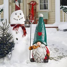 a gnome and snowman in front of a house