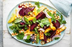 a plate filled with vegetables and chickpeas on top of a white table cloth