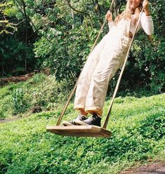 a woman on a swing in the grass