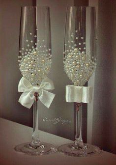 two wine glasses with pearls and bows on them