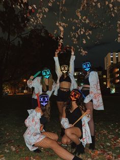 group of people dressed up in costumes posing for the camera with masks on their faces