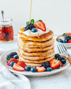 a stack of pancakes topped with fruit and syrup