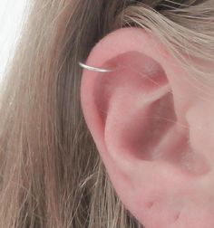 a woman's ear is shown with a single thin bar in the middle