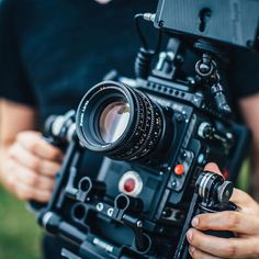 a person holding a camera in their hands with the lens on it's side