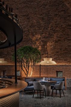 the interior of a restaurant with brick walls and wooden tables, chairs, and lamps