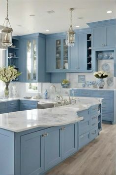 a large kitchen with blue cabinets and white counter tops in the center, along with an island