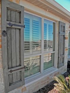 an old window with shutters reflecting the water