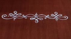 a wooden table topped with white embroidered designs on top of it's wood floor