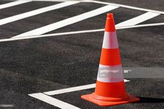 an orange and white cone sitting on top of a parking lot