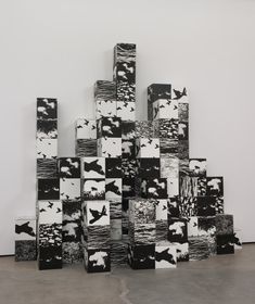 black and white artwork on the wall in an art gallery with concrete blocks stacked together