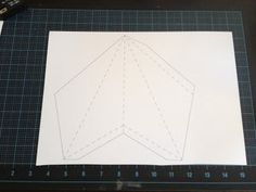 a piece of paper cut out to look like an airplane on a table with rulers