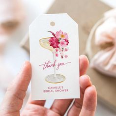 a person holding up a thank you card with flowers in the wine glass on it