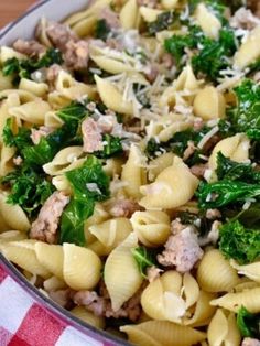 a pan filled with pasta, meat and greens