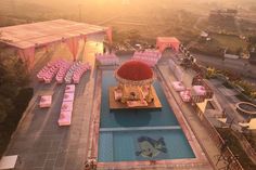 an aerial view of a pool with pink chairs