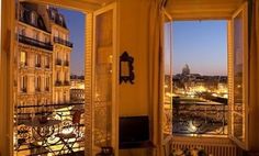 an open window overlooking the city at night