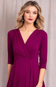 a woman wearing a purple dress with a v - neck and 3 / 4 sleeves